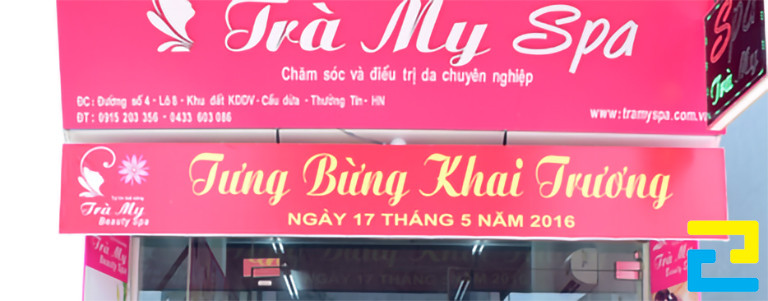 Mẫu 5: Băng rôn được thiết kế đơn giản với màu đỏ chủ đạo, có hình ảnh logo spa, kết hợp với kiểu chữ vàng nổi bật