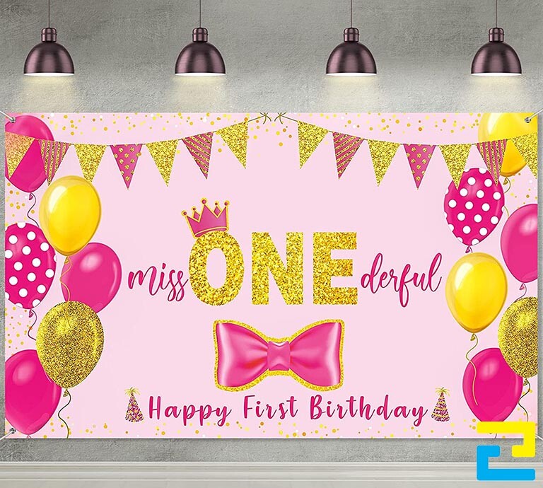 Mẫu 20: Phông nền mừng tiệc thôi nôi có tông màu hồng chủ đạo, có những hình ảnh như: Cờ đuôi nheo, bóng bay, chiếc nơ được thiết kế đẹp mắt