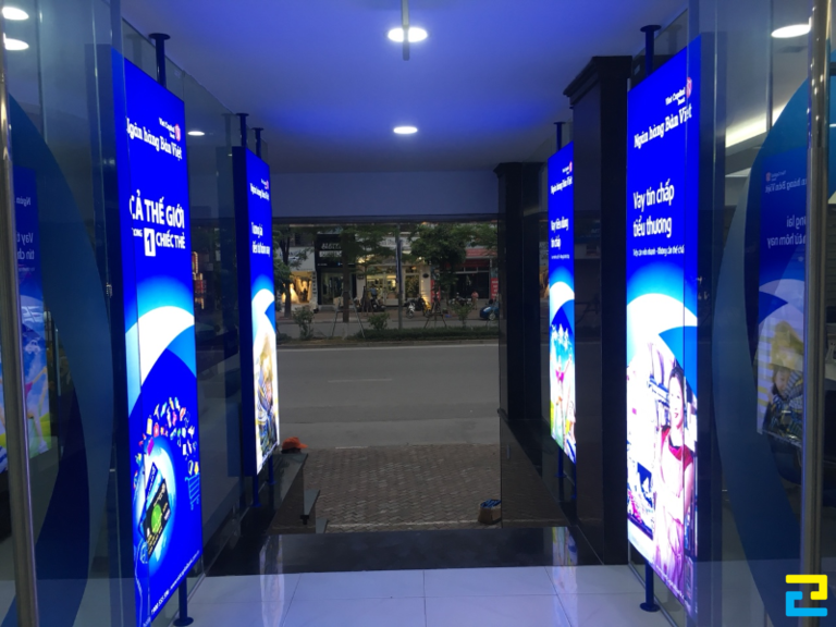 Mẫu bảng hiệu in bạt xuyên đèn với các dịch vụ nổi bật của ngân hàng được đặt ở lối đi